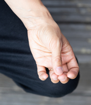 Upturned hand resting on knee